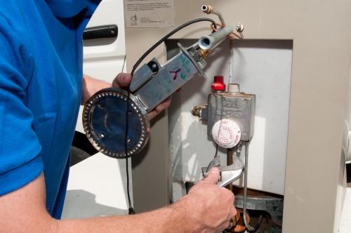 plumber testing a water heater's electronics during a repair call in Lake Forest, CA